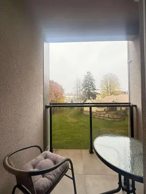 a balcony with a glass table and chairs and a window at Apartman Dentalux 5 in Banja Luka