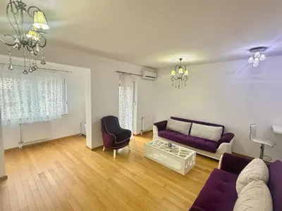a living room with a purple couch and a table at Apartman Dentalux 5 in Banja Luka