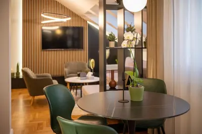 a dining room with a table and green chairs at Aleja Dua in Banja Luka
