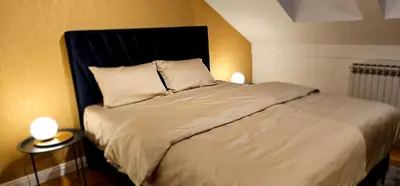 a bedroom with a large bed with two lamps at Aleja Dua in Banja Luka