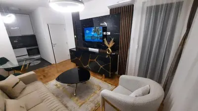 a living room with a couch and chairs and a tv at Zlatni San apartman 1 in Banja Luka