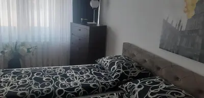 a bedroom with a bed and a dresser with a lamp at Apartment CenterZeroZone in Banja Luka
