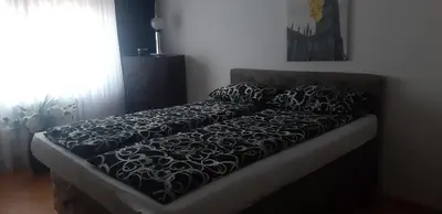 a bed with a black and white blanket on it at Apartment CenterZeroZone in Banja Luka