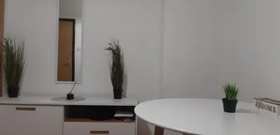 a white table with potted plants on a white wall at Apartment CenterZeroZone in Banja Luka