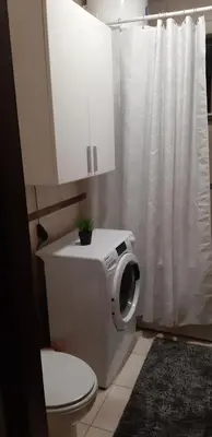 a bathroom with a toilet and a shower curtain at Apartment CenterZeroZone in Banja Luka