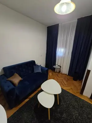 a living room with a blue couch and a table at Apartment CenterZeroZone in Banja Luka