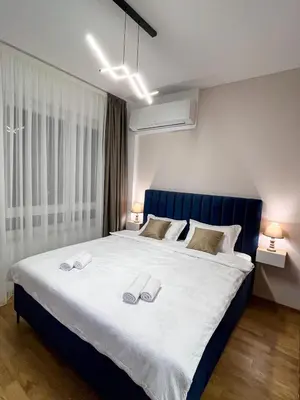 a bedroom with a large bed with two slippers on it at Stan na dan Libero Apartman in Banja Luka