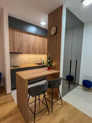 a kitchen with a table and chairs and a clock at Stan na dan Libero Apartman in Banja Luka