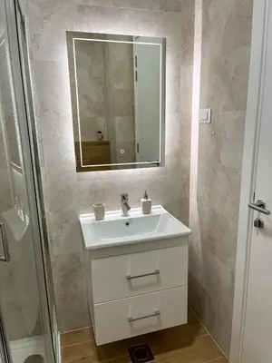 a bathroom with a white sink and a mirror at Stan na dan Libero Apartman in Banja Luka