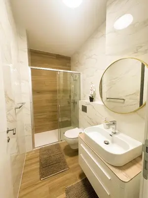 a bathroom with a toilet and a sink and a mirror at KING - Apartment & SPA in Banja Luka
