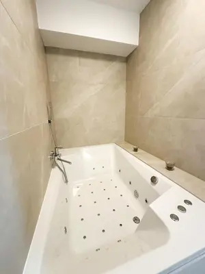 a white bath tub in a bathroom with at KING - Apartment & SPA in Banja Luka
