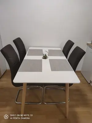 a white table with four black chairs in a room at Hostel Havana in Banja Luka