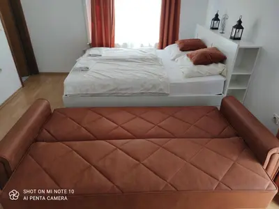 a bed with a brown quilted bench in a bedroom at Hostel Havana in Banja Luka