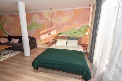 a bedroom with a bed with a green blanket at Hostel Havana in Banja Luka