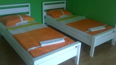 two twin beds in a room with green walls at Hostel Havana in Banja Luka