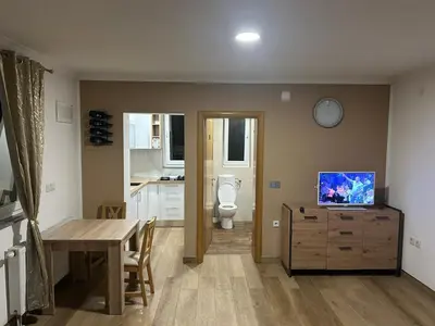 a room with a kitchen with a toilet and a table at Studio apartman Banja Luka in Železnička Stanica Banja Luka Predgrađe