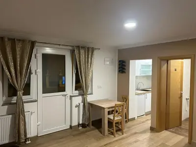 a kitchen with a table and a dining room at Studio apartman Banja Luka in Železnička Stanica Banja Luka Predgrađe