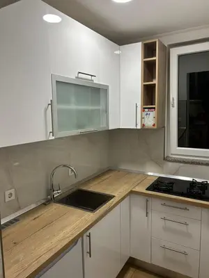 a kitchen with white cabinets and a sink and a window at Studio apartman Banja Luka in Železnička Stanica Banja Luka Predgrađe