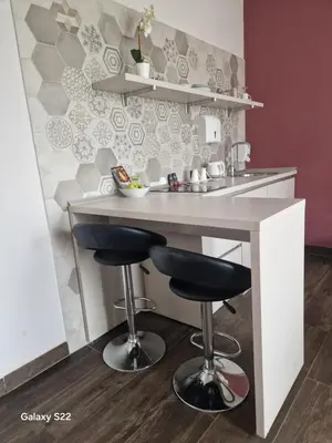 a kitchen with a bar with two stools at Apartmani Prag in Banja Luka