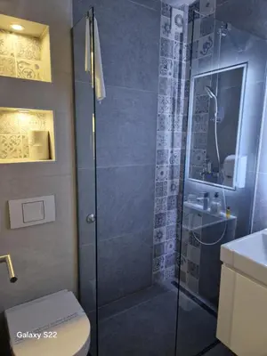 a bathroom with a shower with a toilet and a sink at Apartmani Prag in Banja Luka