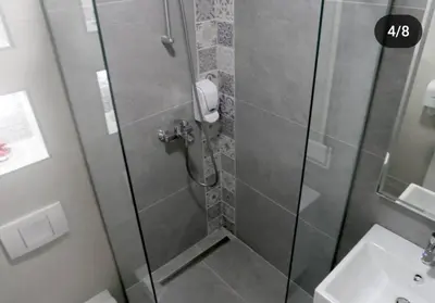 a shower with a glass door next to a sink at Apartmani Prag in Banja Luka
