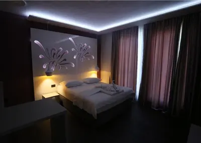 a bedroom with a bed with a flower mural on the wall at Apartmani Prag in Banja Luka