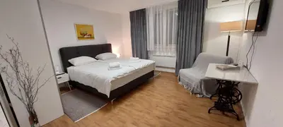 a hotel room with a bed and a chair at Stepa apartman in Banja Luka