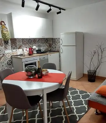 a kitchen with a white table and chairs and a white refrigerator at Stepa apartman in Banja Luka