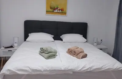 a bed with two towels sitting on it at Stepa apartman in Banja Luka