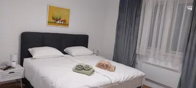 a bedroom with a bed with towels on it at Stepa apartman in Banja Luka