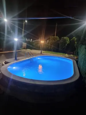 a large blue swimming pool at night with lights at Villa Alejna in Gradačac
