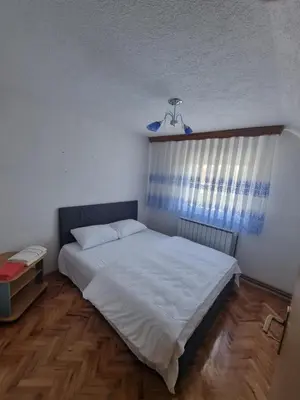 a bedroom with a white bed and a window at Villa Alejna in Gradačac