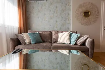 a living room with a brown couch with pillows at Apartman Platinum in Banja Luka