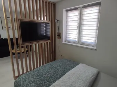 a bedroom with a bed and a flat screen tv at Studio apartman Čolić - Kupres in Kupres