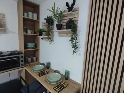 a kitchen with a table with plates and plants at Studio apartman Čolić - Kupres in Kupres