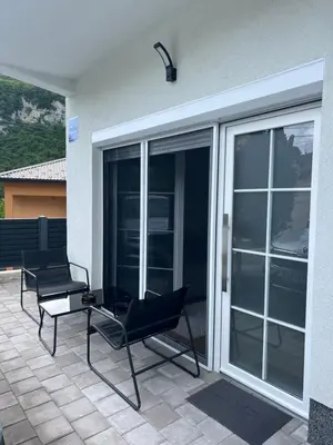 two black chairs sitting on a patio with sliding glass doors at Home Away From Home 2 in Jajce