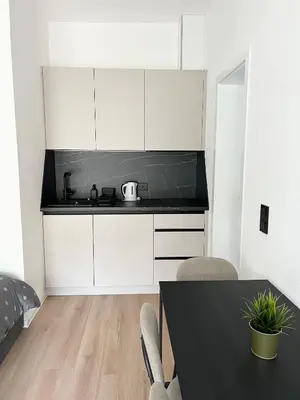 a kitchen with white cabinets and a black counter top at Home Away From Home 2 in Jajce