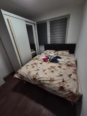 a bedroom with a bed with a flower comforter at Zevs Apartman in Prijedor