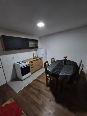 a kitchen with a table and a stove top oven at Zevs Apartman in Prijedor