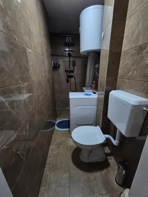 a small bathroom with a toilet and a shower at Zevs Apartman in Prijedor