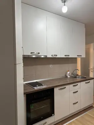 a kitchen with white cabinets and a sink and a stove at Stay inn Tuzla in Tuzla