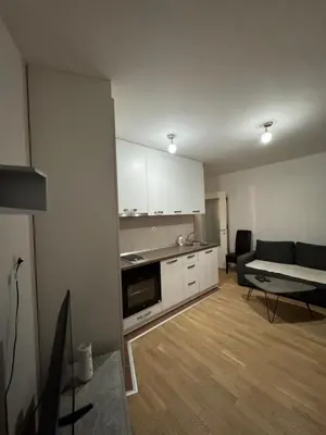 a kitchen and living room with a couch and a table at Stay inn Tuzla in Tuzla