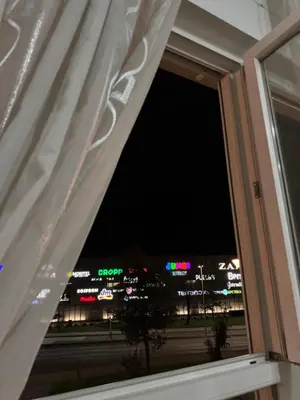 a window with a view of a city at night at Stay inn Tuzla in Tuzla