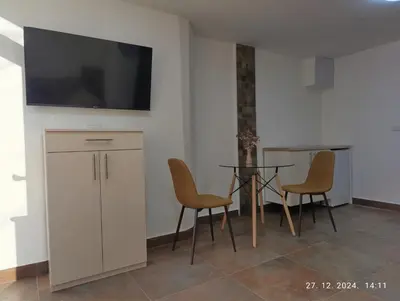 a dining room with a table and chairs and a tv at Stan Banja Luka in Banja Luka