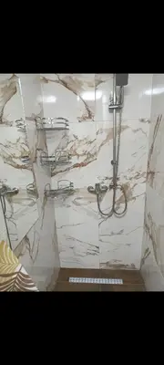 a bathroom with a shower with marble walls at Stan Banja Luka in Banja Luka
