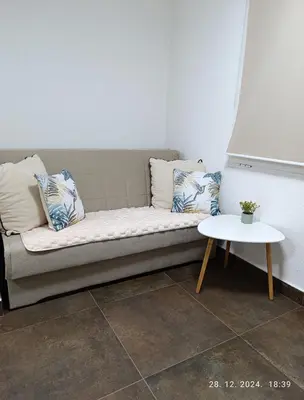 a couch with pillows and a table in a room at Stan Banja Luka in Banja Luka