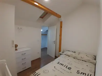 a bedroom with a white bed and a white dresser at Apartman Gold&Black Banja Luka in Banja Luka