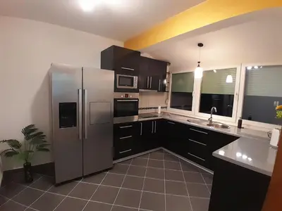 a large kitchen with a stainless steel refrigerator at Apartman Gold&Black Banja Luka in Banja Luka