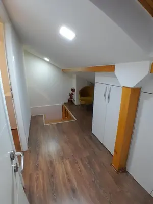 an attic room with a kitchen and a staircase at Apartman Gold&Black Banja Luka in Banja Luka