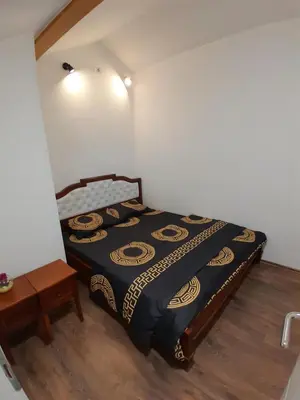 a bedroom with a bed in the corner of a room at Apartman Gold&Black Banja Luka in Banja Luka